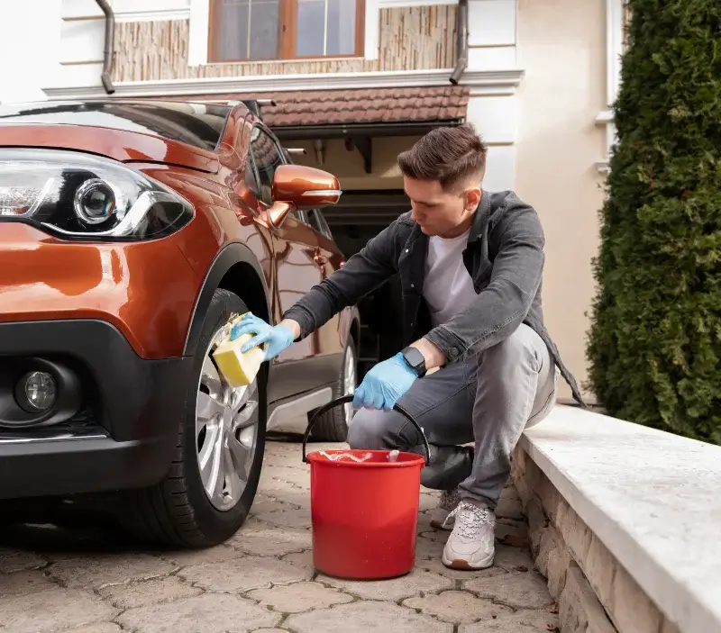 Lavage auto à domicile Tourville-sur-Sienne : professionnel intervenant sur un véhicule